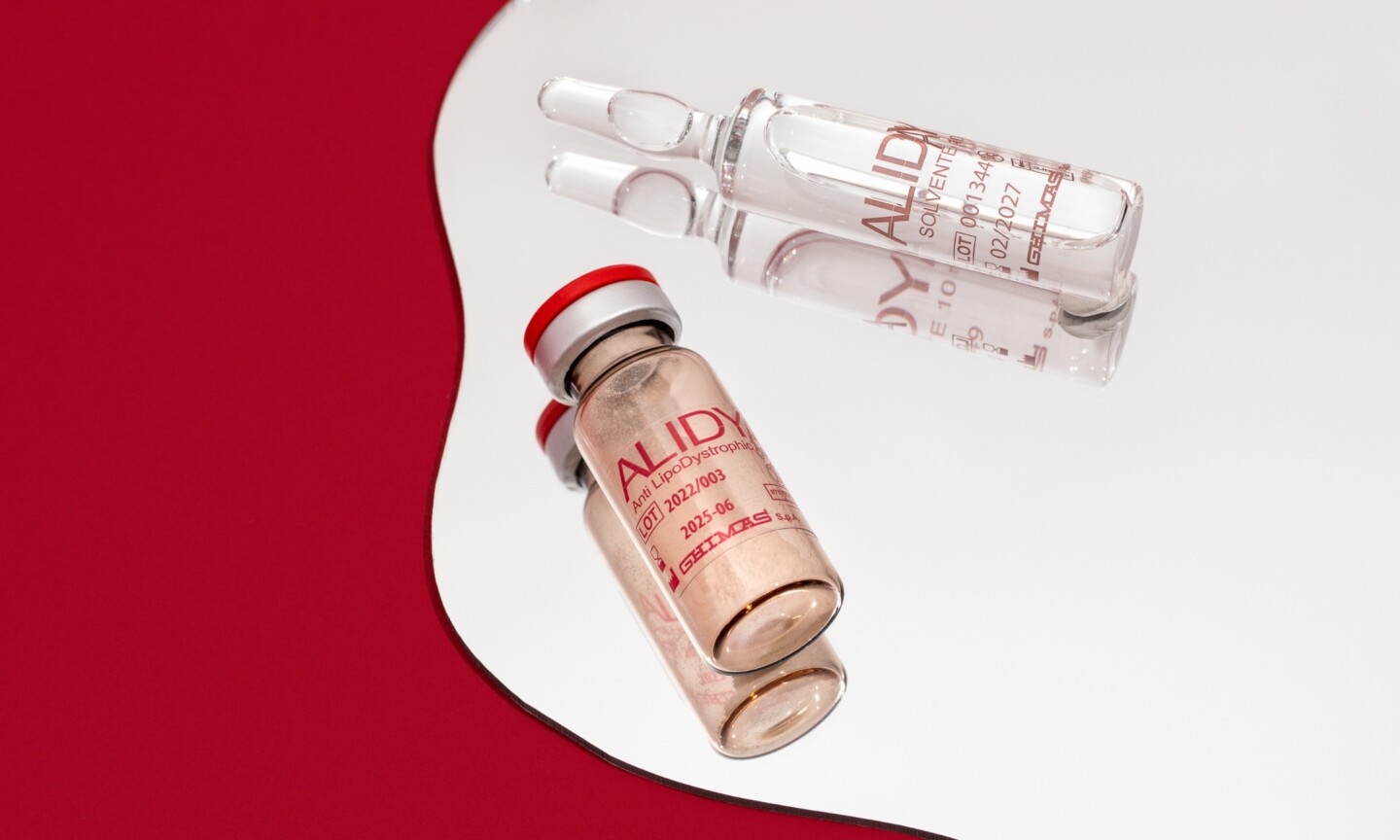 Alidya cellulite treatment vial and glass ampoule resting on a mirror surface, featured on Beauty News Daily