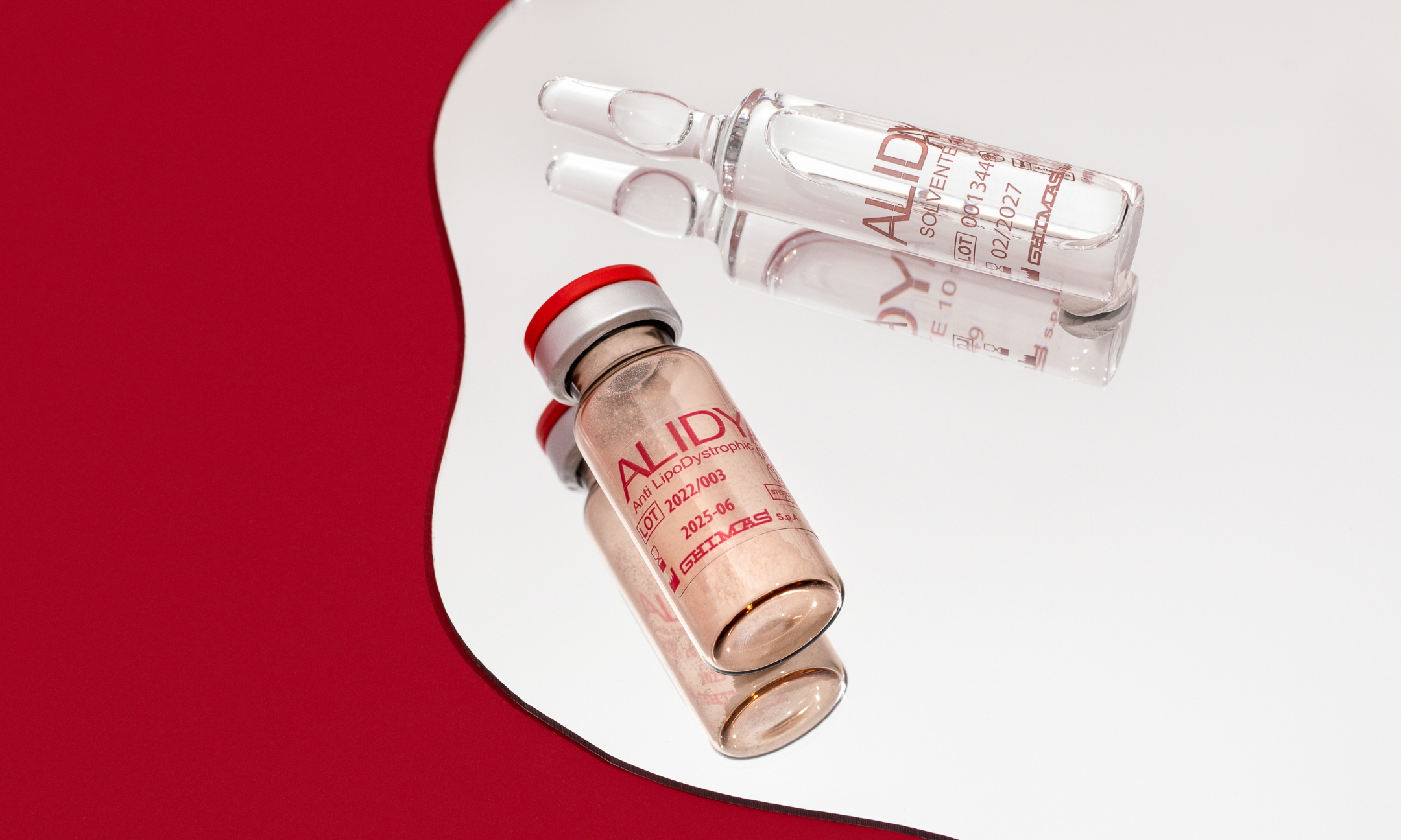 Alidya cellulite treatment vial and glass ampoule resting on a mirror surface, featured on Beauty News Daily