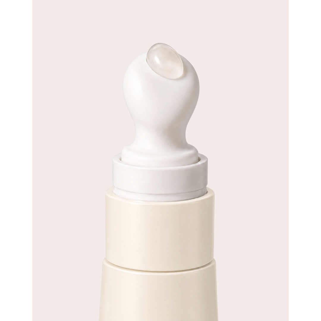 A close-up view of the cream-coloured tube and rounded applicator tip of Byorbe Lip Barrier Balm Daily SPF 50 with a drop of clear product on the tip.