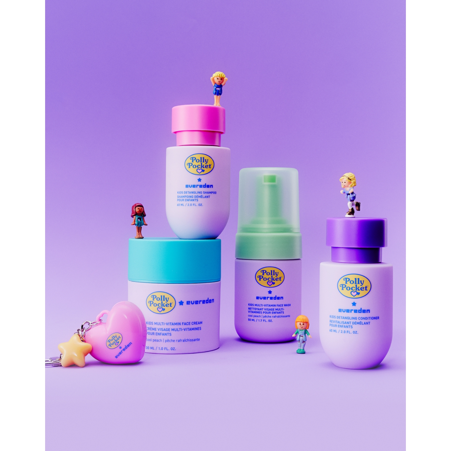Evereden x Polly Pocket pink heart keychain and kids skincare and hair care products displayed against a purple background, featuring miniature Polly Pocket figures standing on the products.