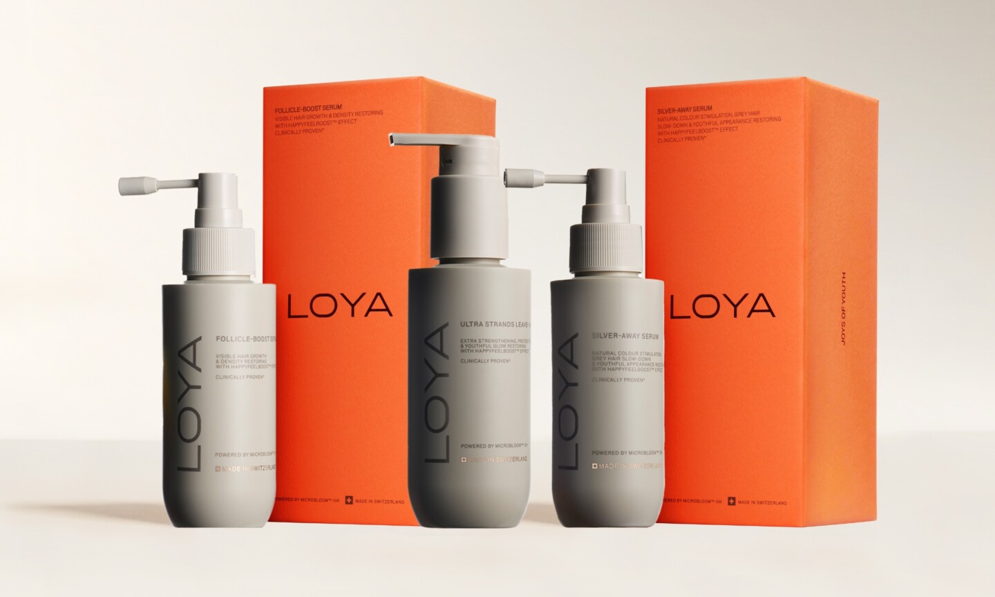 The new Loya haircare range featuring grey product bottles and orange packaging boxes, featured on Beauty News Daily.