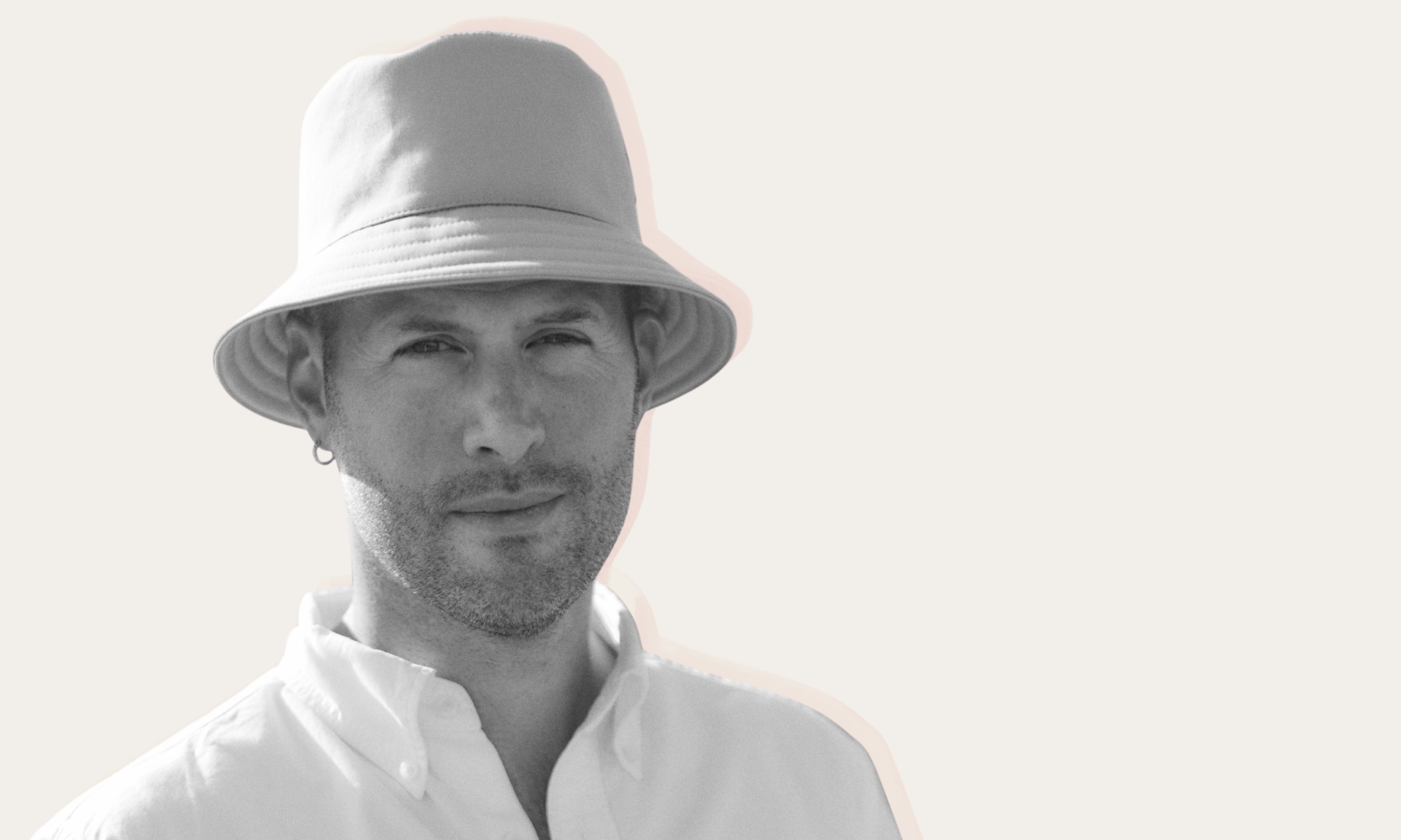 Black-and-white portrait of designer Marc-Antoine Barrois wearing a bucket hat and a white button-up shirt.