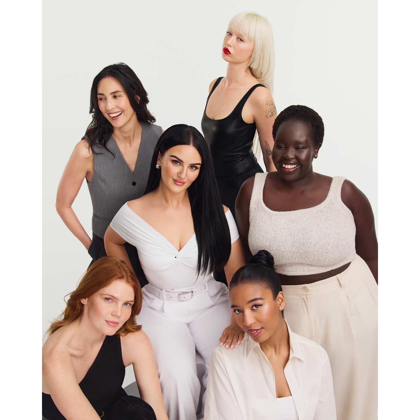 Mikayla Nogueira seated at the center in an off-the-shoulder white top, surrounded by five diverse models wearing neutral and black outfit styles in a campaign photo for POV Beauty.