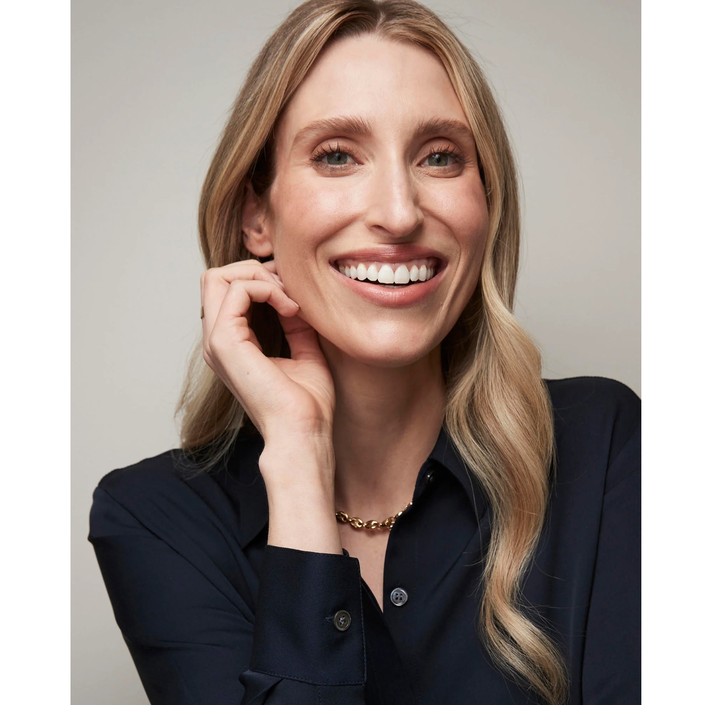Board-certified dermatologist and Prequel founder Dr Sam Ellis (Dr Samantha Ellis) smiling in a navy blue shirt against a neutral backdrop.