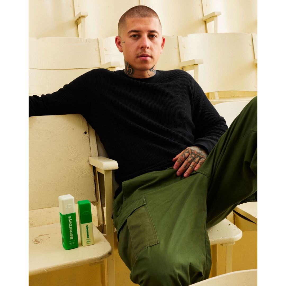 Victor Fontanez (VicBlends) sitting on auditorium seating next to BetterDays Rebound Cream and Grip Powder products.