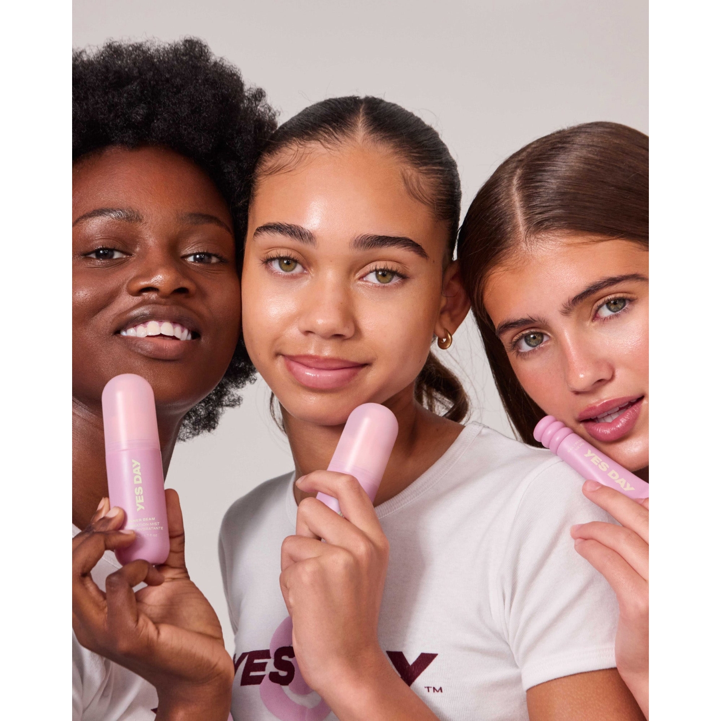 Three models, including Coco Granderson, holding pink Yes Day skincare products including the Inner Beam Hydration Mist and Lip Sweetie Lip Mask, featured in the brand's Urban Outfitters launch announcement on Beauty News Daily.